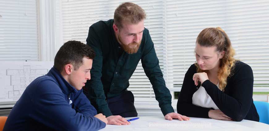 Two adult students talk to Lecturer