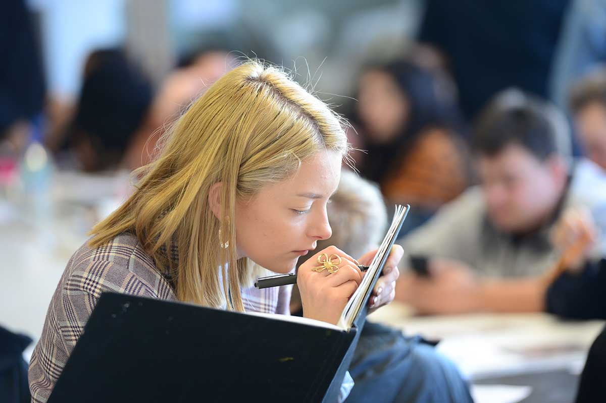 Girl drawing in book