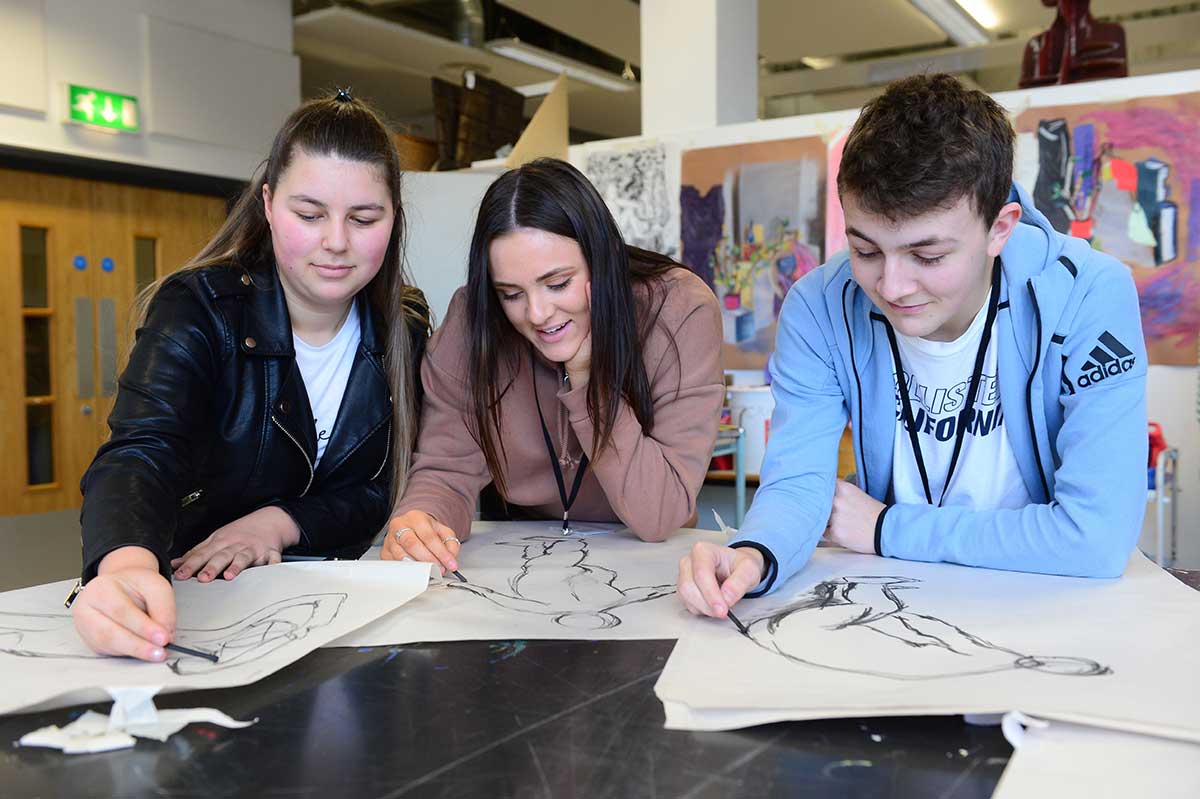 Students sketching at table