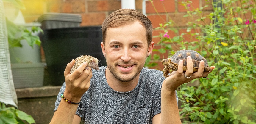 Josh Carter holding a hedgehog and a turtle