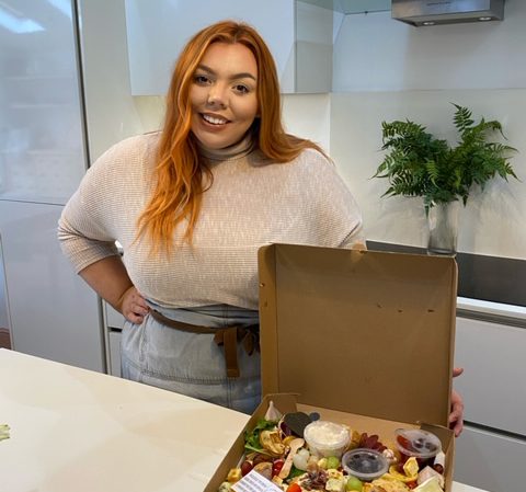 Libbi Myers opening a snack box in her shop