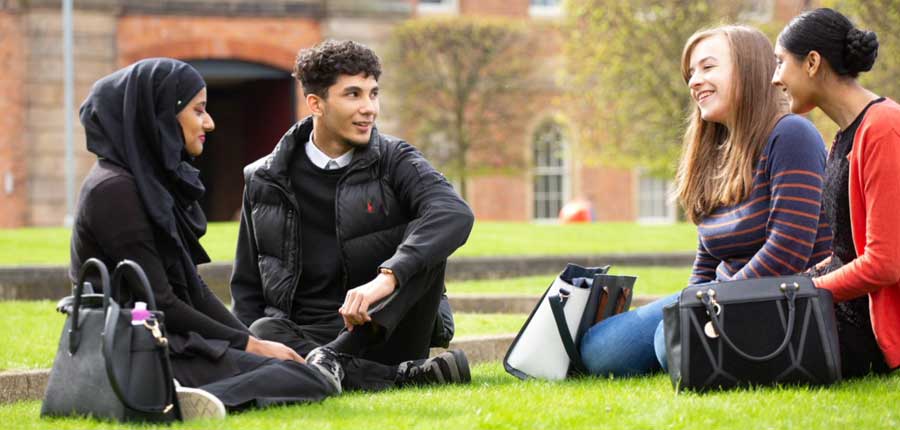 students sitting on grass outside the roundhouse