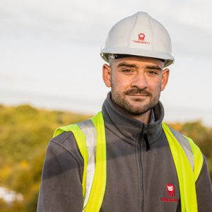 Ed Smith wearing Tomlinson PPE and hard hat on a building site