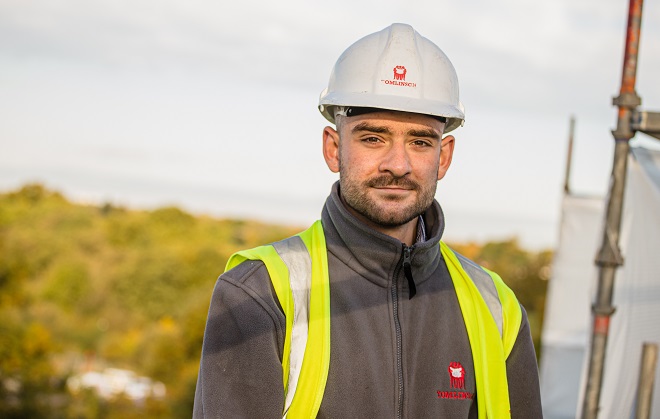 Ed Smith wearing Tomlinson PPE and hard hat on a building site