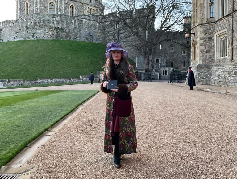 DCG CEO Mandie Stravino holding her OBE outside of Windsor Castle.