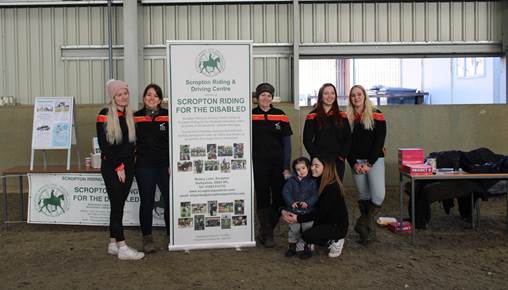 Equine students at Broomfield Hall stood next to a banner for Scropton Riding for the Disabled.