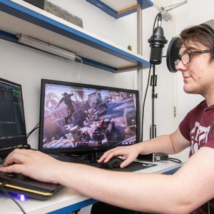 Former Games Development student Jordan Thorpe using a laptop computer.