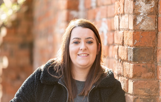 Sophie Smyth leant against a brick wall.