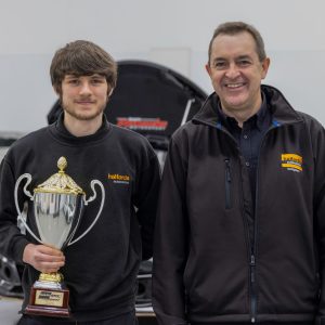 Halfords Apprentice of the Year Cameron Palmer holding his trophy stood next to Andy Randall, Chief Operating Officer of Halfords.