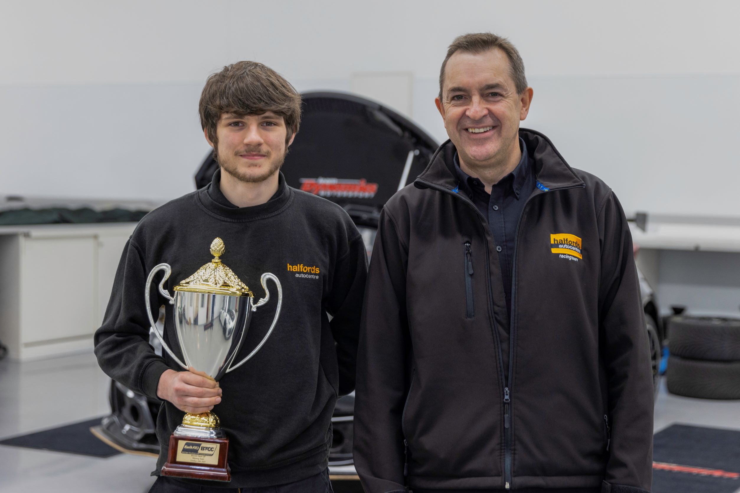 Halfords Apprentice of the Year Cameron Palmer holding his trophy stood next to Andy Randall, Chief Operating Officer of Halfords.