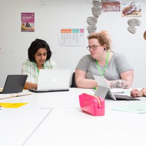 Four mature Teacher Training students sat around a table talking to one another.