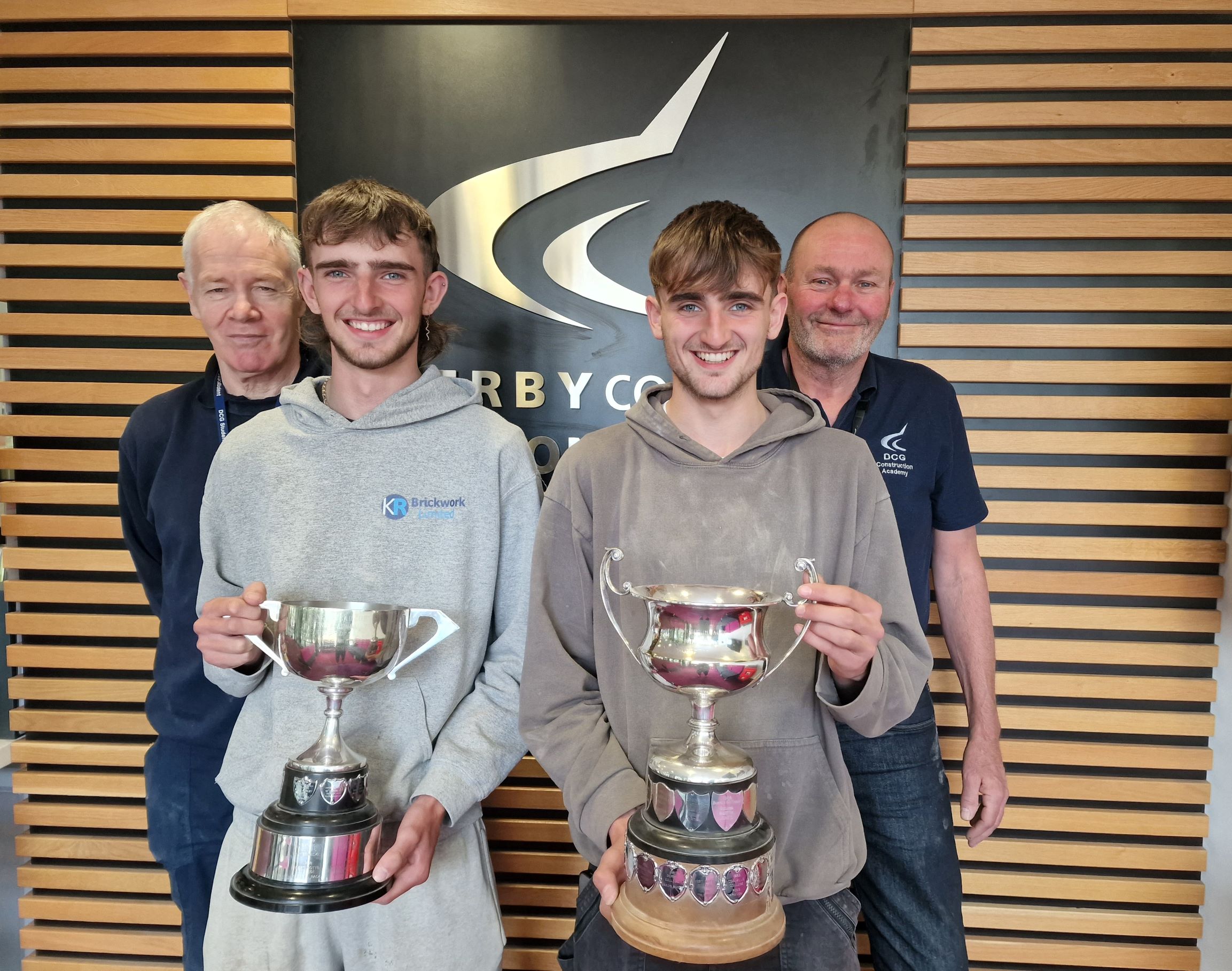Bricklaying students Jonny and George McFarlane holding their awards stood with teachers Bill Bentley and Clive Smith.
