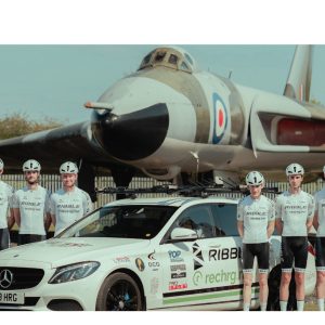 Members of the RIBBL Rechrg team stood by a car and in front of a jet.