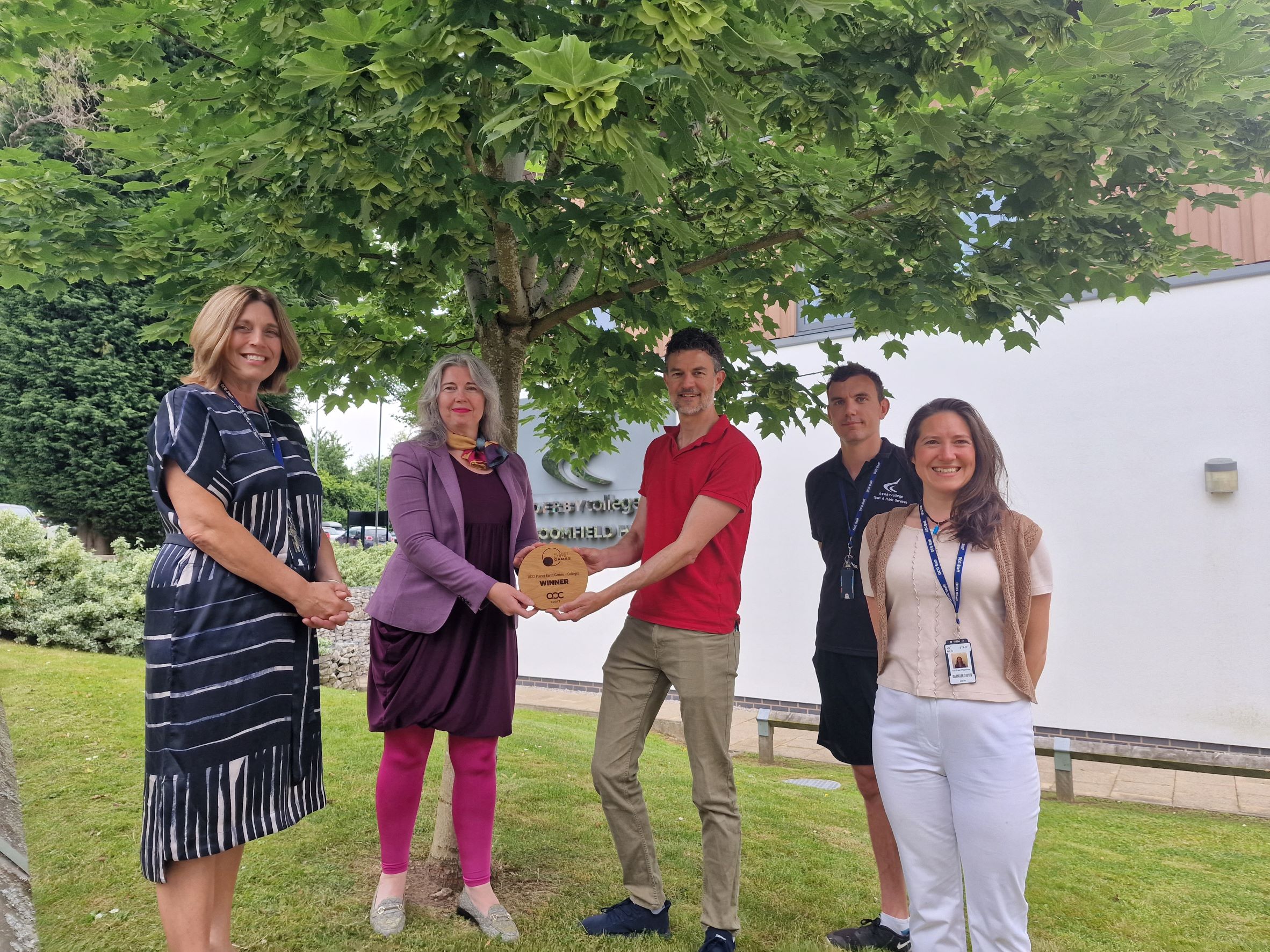 Founder of Planet Earth Games, Chris Broadbent presents the Planet Earth Games trophy to DCG CEO Mandie Stravino alongside DCG deputy CEO Heather Simcox, Sport and Public Services teacher Phil Kilpatrick and DCG environmental and sustainability officer Rachael Willshaw.
