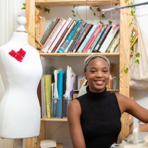 Former Derby College Art & Design student Lizzie Seyi stood next to a mannequin.