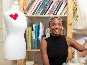 Former Derby College Art & Design student Lizzie Seyi stood next to a mannequin.