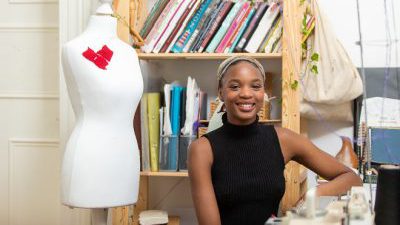 Former Derby College Art & Design student Lizzie Seyi stood next to a mannequin.