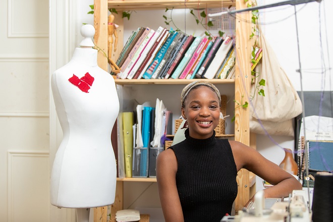 Former Derby College Art & Design student Lizzie Seyi stood next to a mannequin.