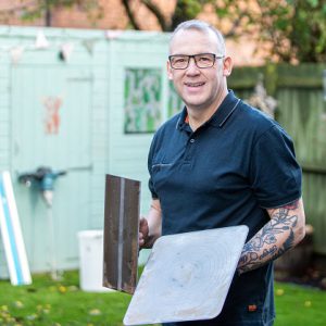 Andy Walker holding plastering tools.