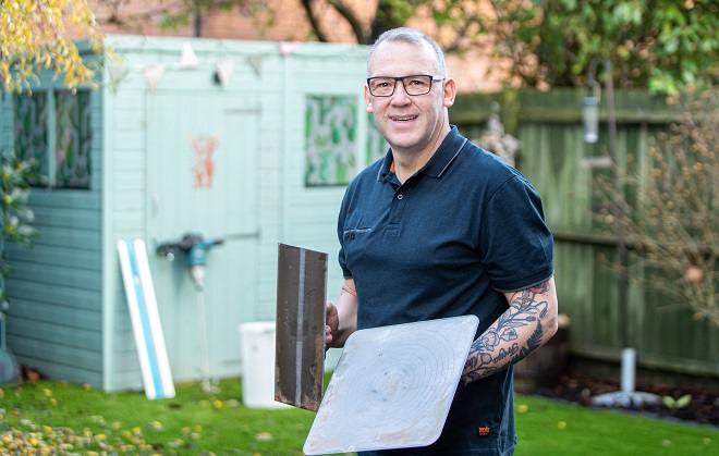 Andy Walker holding plastering tools.