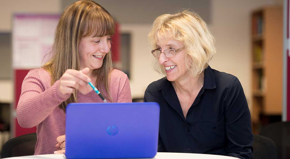 Two females working at a laptop