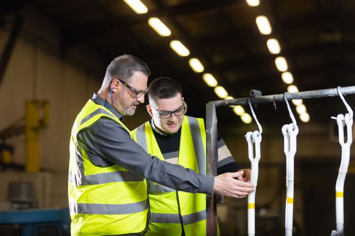 Luke Payne learning from his employer, Richard Whitehead, at work.