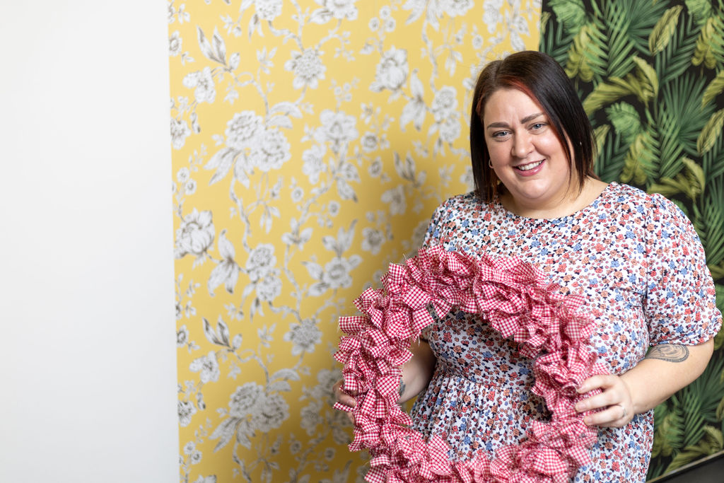 Introduction to Upcycling teacher Laura Smith holding a wreath she created.