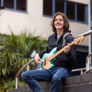 Declan Dean playing his guitar outside of the Joseph Wright Centre.