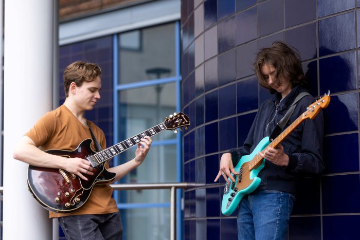 Owen and Declan jamming with their guitars outside of The Joseph Wright Centre.