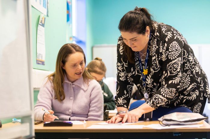 Female adult maths student being taught by a female teacher.