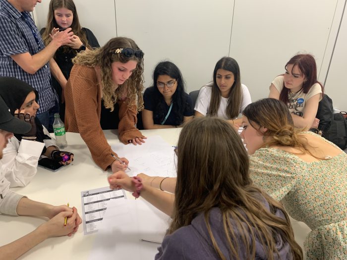 GCSE Plus students at the Guardian workshops, pointing at a piece of paper.