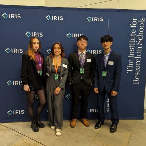 Four students at the IRIS Awards stood against a blue backdrop.