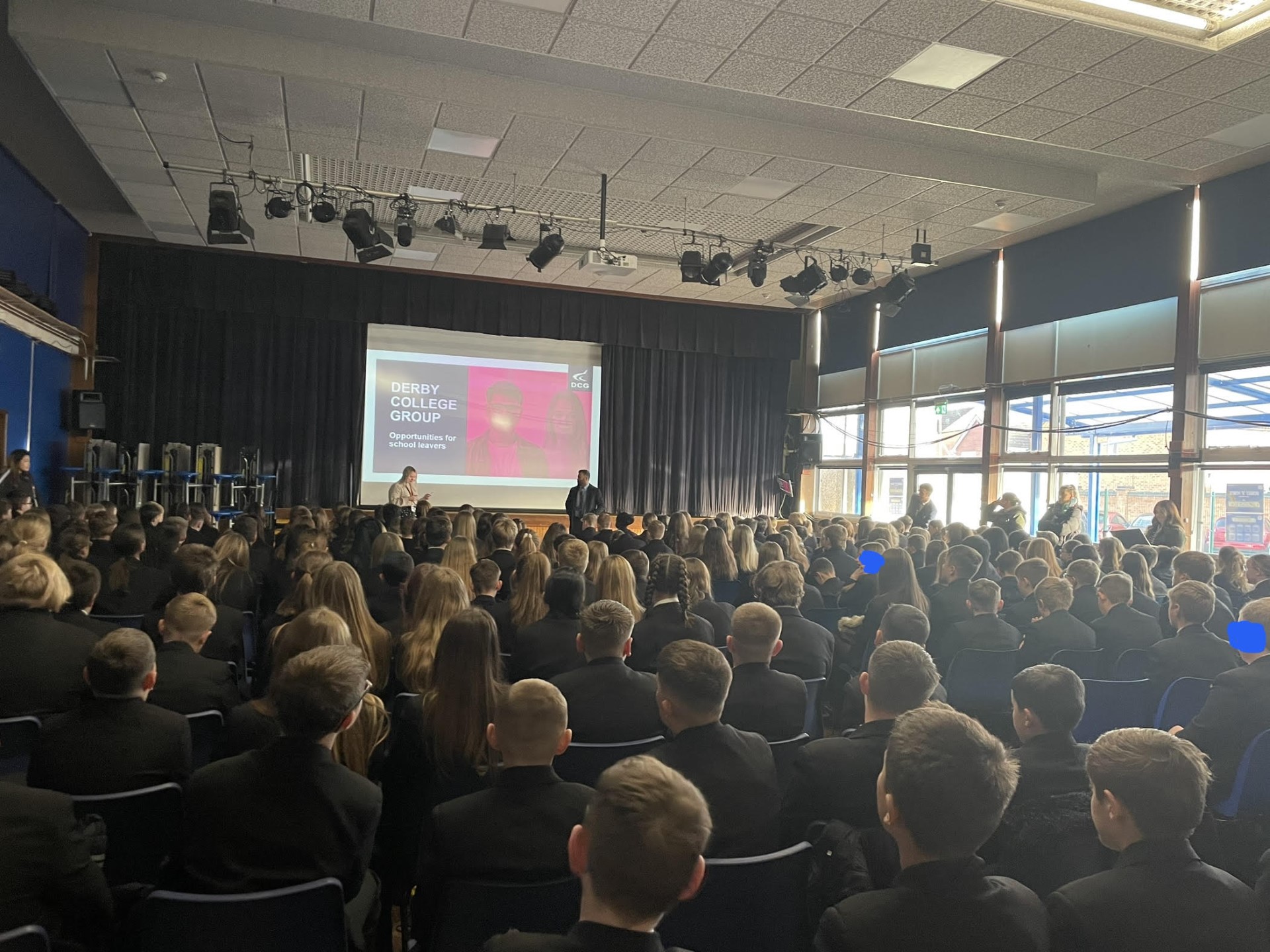 Backs of heads of students watching a presentation at school.