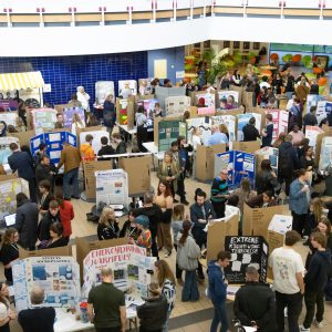 People in a big room looking at students' projects.