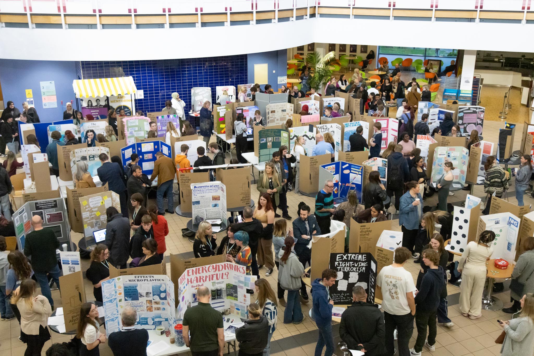 People in a big room looking at students' projects.