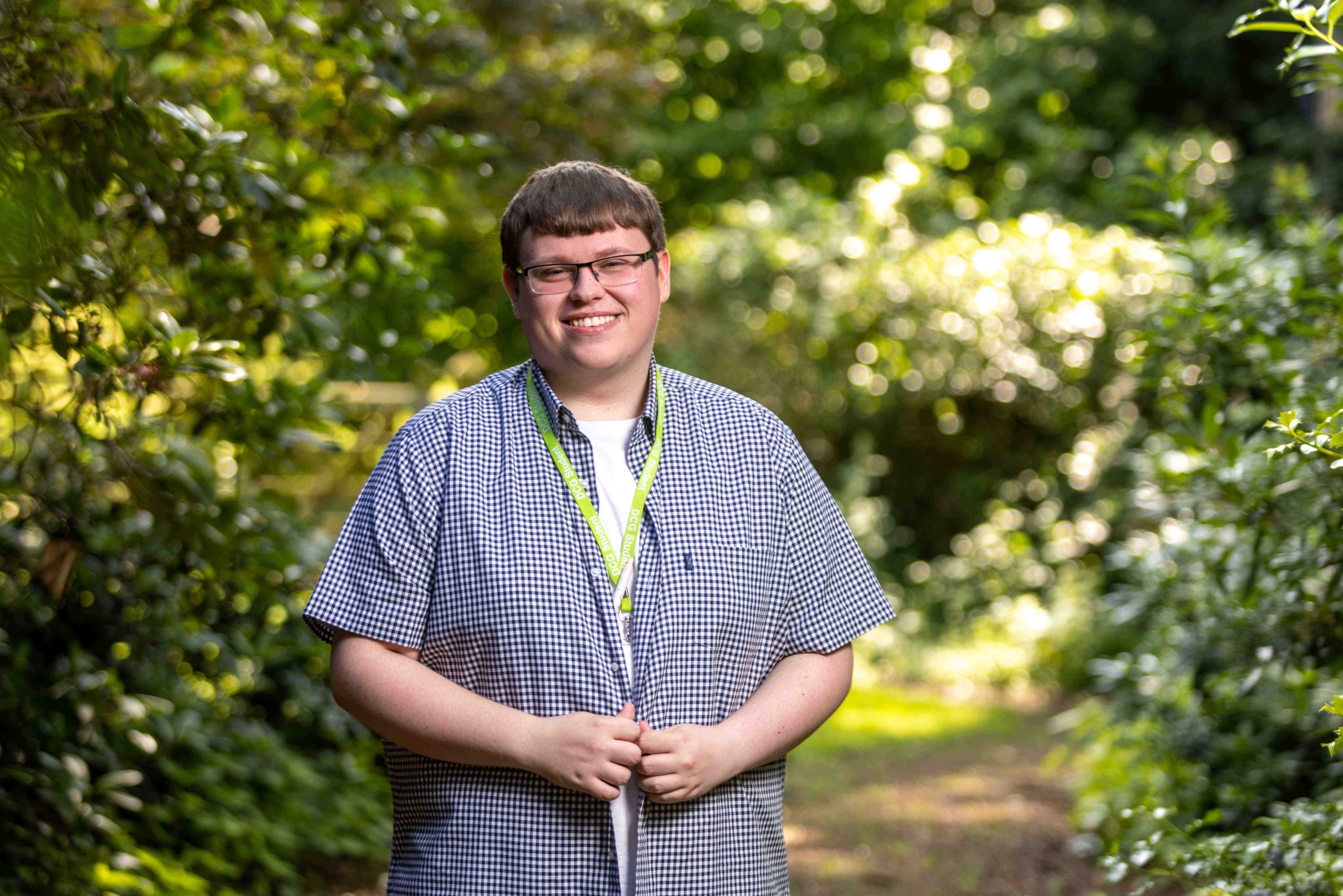 Roman Morley stood smiling by a bush.