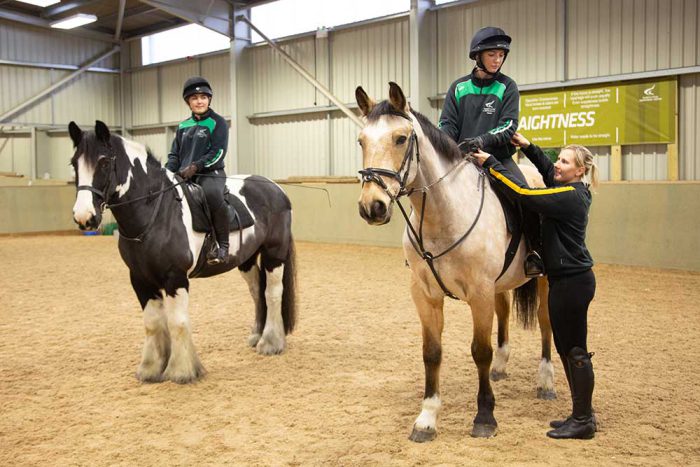 Two equine students sat on the back of their horses.