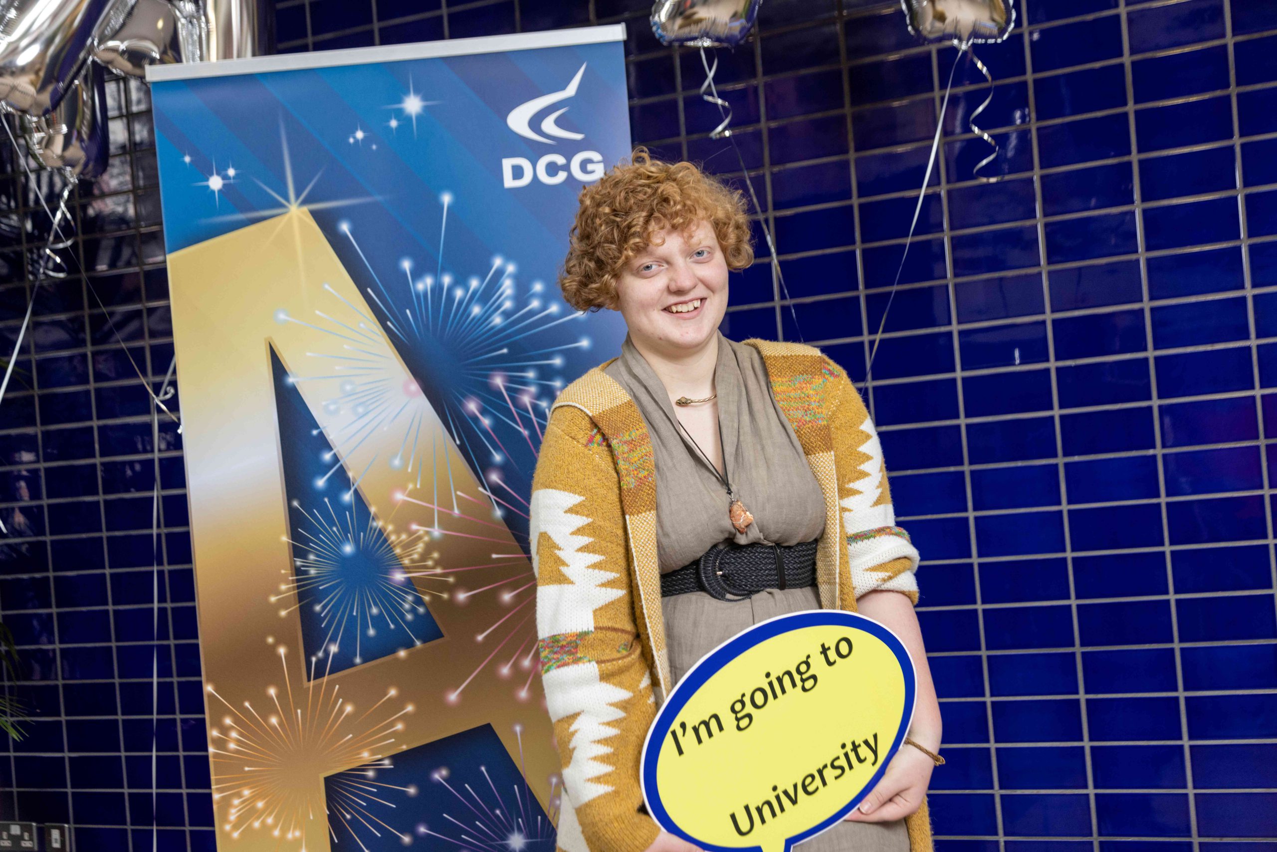 Young female with curly hair holding a sign with writing on it.