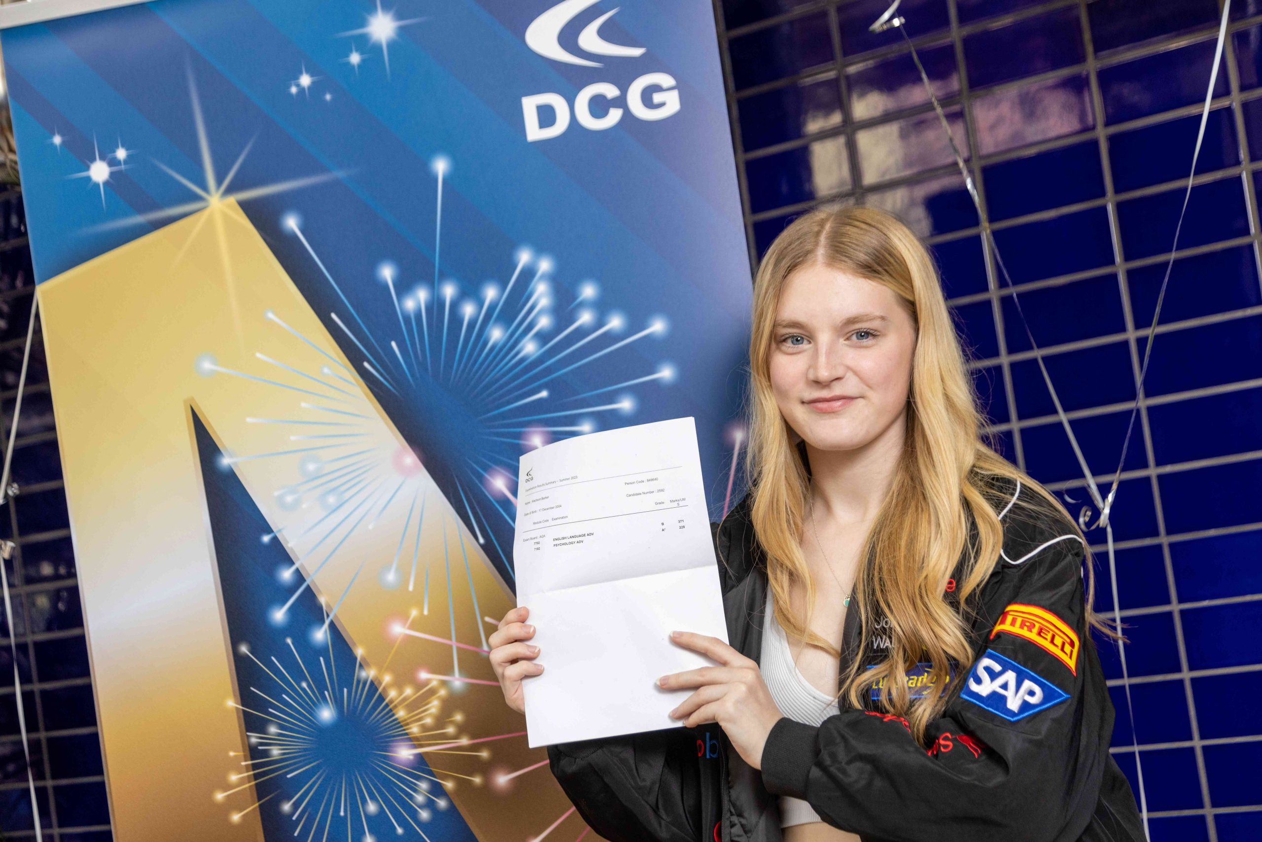 Young female student with blonde hair and a black coat holding a document with exam results on.