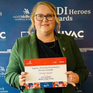 Linzie Smithies, a blinde haired woman wearing a green cardigan holding a certificate