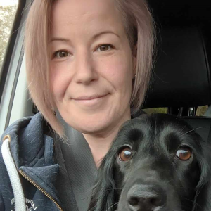 Sarah Lowe, a former DCG Dog Grooming student with her dog, a black cocker spaniel.