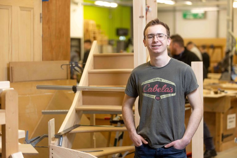 Young apprentice Kai stood in the carpentry workshop.