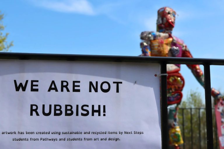 Sculpture made from rubbish with a plaque reading 'We Are Not Rubbish'