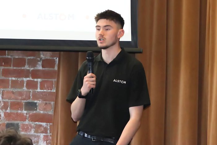 Young apprentice speaking into a microphone.
