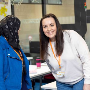Two teaching apprentices smiling at one another.