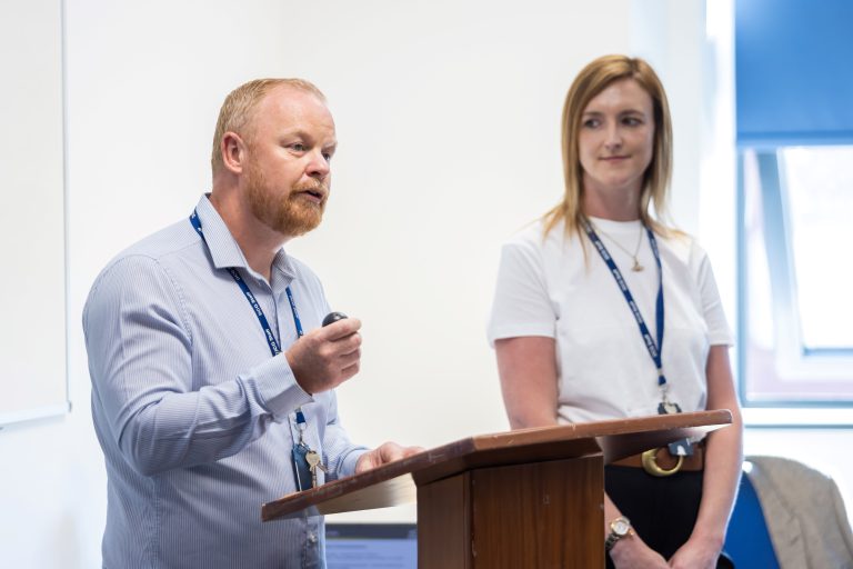 A man addressing an audience at a lectern