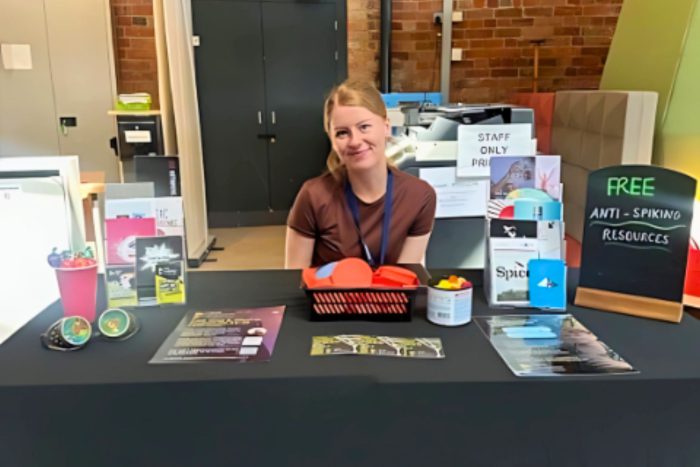 Person sat at a stall with a display with flyers and other material