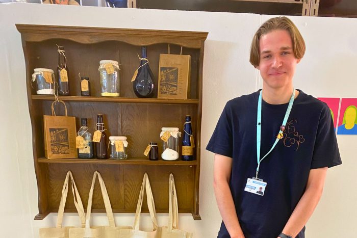 Young student stood by pieces of art they have created.