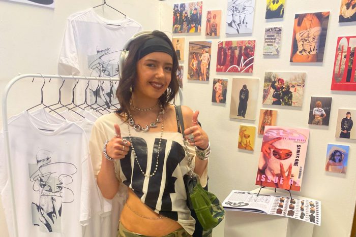 Young student stood by pieces of art they have created.