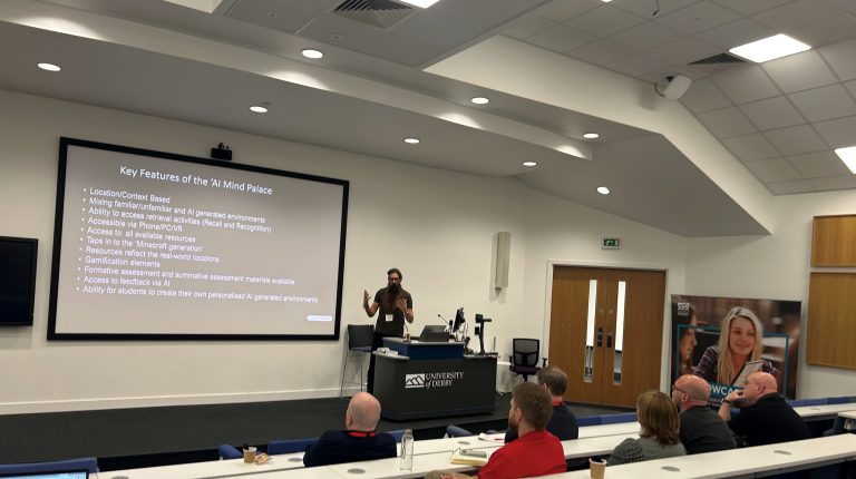 Man with big beard talking an audience in a lecture theatre